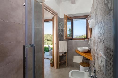 bagno con doccia, lavandino e specchio di La casa di Memmi Suites & Rooms a Santa Teresa di Gallura