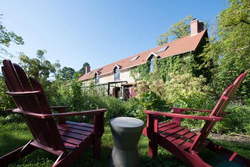 two rocking chairs sitting next to a house at Chambres de La Barboire Campagne in Saint Laurent Nouan