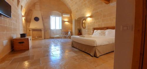 a bedroom with a bed and a stone wall at Due forni affittacamere in Matera