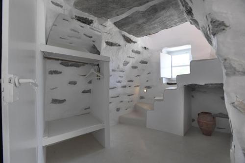 a staircase in a room with a stone wall at The stone in Tinos