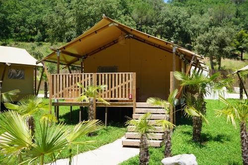 a small building with a porch in a yard at Glamping Can Bora Lodges in Las Serras