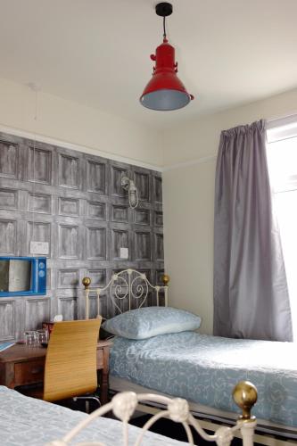 a bedroom with two beds and a desk with a lamp at Bedlam House in Newquay