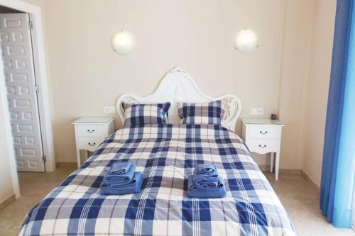 um quarto com uma cama com sapatos azuis em Apartamento ARCE NSF M- TORRECILLA NERJA em Nerja
