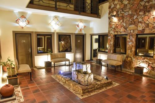 a living room with a stone fireplace and a fish tank at Hotel Inkai in Salta