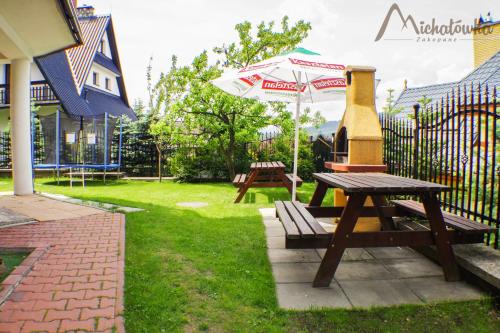 a picnic table with a grill and an umbrella at Willa Michałówka in Zakopane