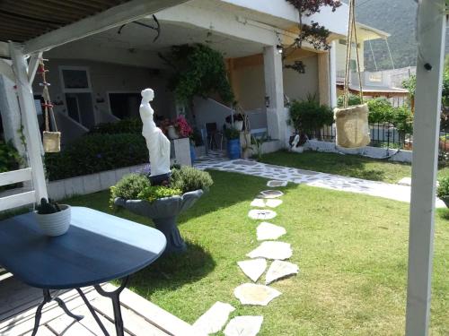 a garden with a table and a statue in a yard at Blue Dreams in Almiropótamos