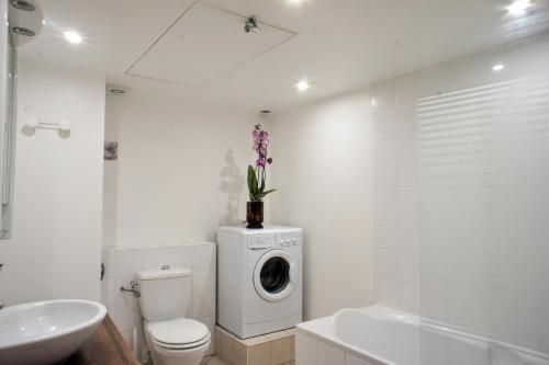 une salle de bain blanche avec une machine à laver à l'intérieur dans l'établissement Ze Perfect Place - Spacieux appartement - Cours Saleya - 2 CHB - 2 SDB - AC, à Nice