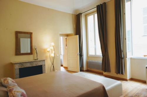 een slaapkamer met een bed, een open haard en een spiegel bij Ze Perfect Place - Spacieux appartement - Cours Saleya - 2 CHB - 2 SDB - AC in Nice