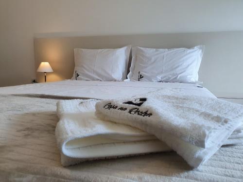 a bed with white towels and pillows on it at Espaço Casa na Rocha in São José dos Campos