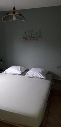 ブレーデネにあるAppartement à Bredene au rez-de-chausséeの枕が2つ置かれた白いベッド
