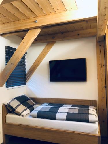 a loft bed with a tv on a wall at Kameňácká myslivna in Moravany
