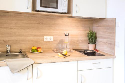 uma cozinha com um lavatório e um balcão com fruta em A2 Boarding House Memmingen em Memmingen