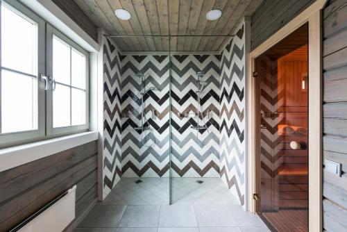 a bathroom with a chevron pattern on the wall at Sala Resort Plateliai & SPA in Plateliai