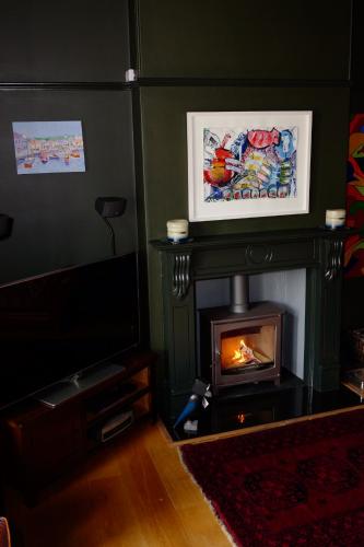 a living room with a fireplace and a television at Bedlam House in Newquay