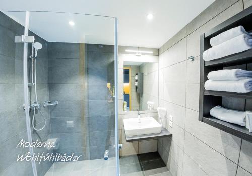 y baño con ducha, lavabo y espejo. en MY HOME MY HOTEL Rosenheim en Rosenheim