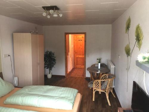 a room with a bed and a table and a door at Deutsches Haus in Neuhütte