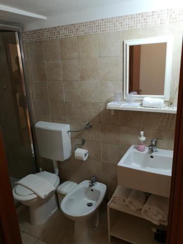 a bathroom with a toilet and a sink and a mirror at B&B Corte San Giuseppe in Casarano