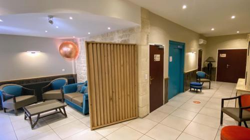 a lobby with a waiting room with blue chairs at Logis - Le Christina in Bourges
