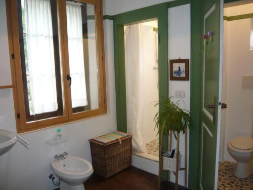 a bathroom with a sink and a toilet and a window at Bed & Breakfast Villa Buzzati in Belluno
