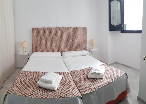 1 dormitorio con 1 cama con 2 toallas en Casa S. XIX en pleno centro de Carmona, en Carmona