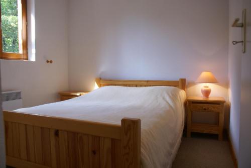 een slaapkamer met een bed en een lamp op een nachtkastje bij Ranfolly 10 in Morzine