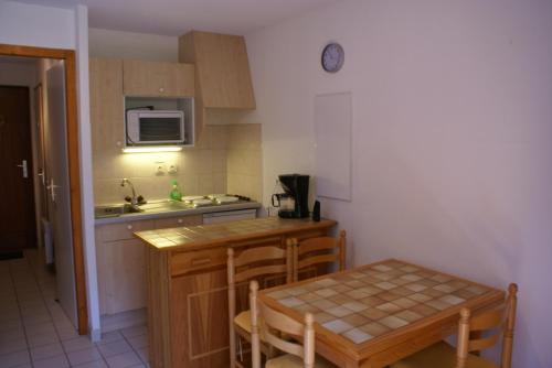 een kleine keuken met een tafel en een magnetron bij Ranfolly 10 in Morzine