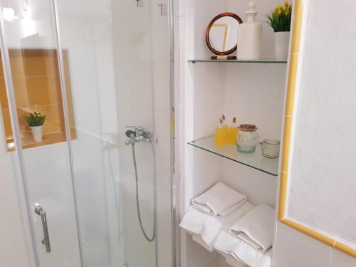 y baño blanco con ducha y toallas. en Casa S. XIX en pleno centro de Carmona, en Carmona
