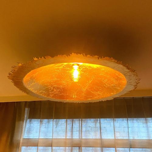 an orange light hanging from a ceiling at Logis - Le Christina in Bourges