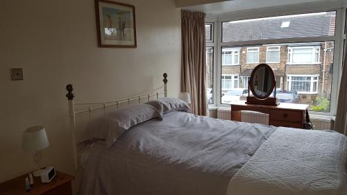 a bedroom with a bed and a large window at Beverley East Townhouse Free Parking in Beverley