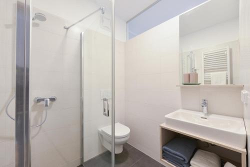 a bathroom with a toilet and a sink and a shower at 23-hotel in Schwadorf