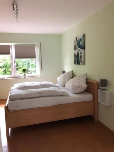 a bedroom with a large bed with two windows at Ferienwohnung Zenzen in Cochem