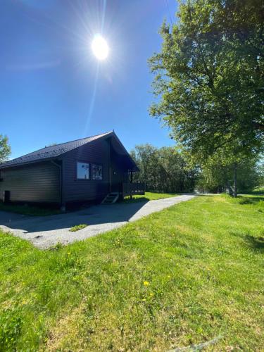 a building with the sun shining on top of it at Saltstraumen Fjordhytter in Knapplund