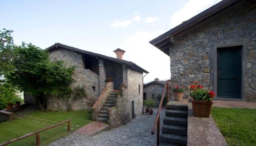 a stone building with a staircase next to a house at Costa D'Orsola in Pontremoli