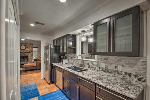 a kitchen with a sink and a refrigerator at 2-Story Pensacola Home with Game Room and Private Yard in Pensacola