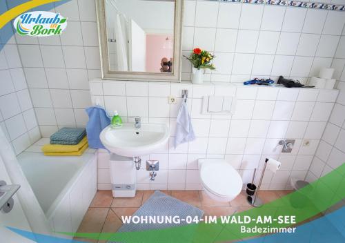 La salle de bains est pourvue d'un lavabo, de toilettes et d'un miroir. dans l'établissement Jagd-Angler-Suite-04-im-Wald-am-See, à Kyritz