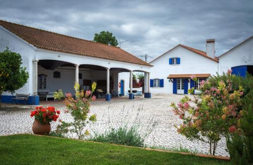 a courtyard of a white building with blue doors at Marchanta in Santarém