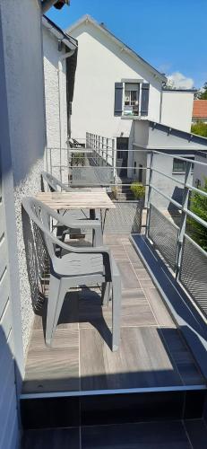 a wooden deck with a picnic table on a balcony at Les Appartements du 104 in Saint-Jean-de-Monts