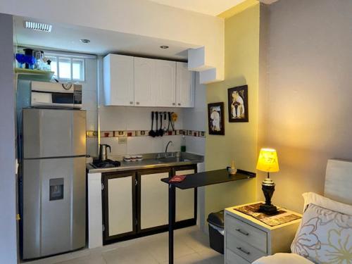 a kitchen with a refrigerator and a table in a room at Apartaestudio El Lugar Ideal Cra. 62 #74-143. in Barranquilla
