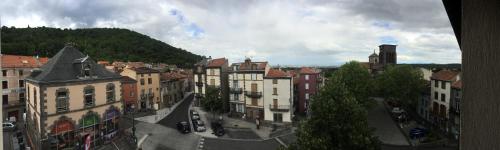 widok na miasto z budynkami i ulicą w obiekcie Logis Hôtel du Commerce w mieście Volvic