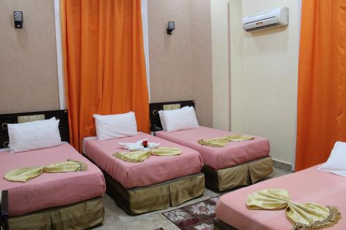two beds in a room with yellow walls at City View Hotel in Cairo