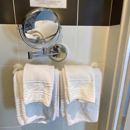 a mirror and two towels in a bathroom at Logis - Le Christina in Bourges