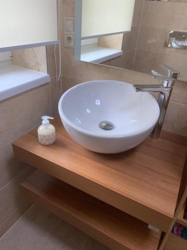 a white sink sitting on a wooden counter in a bathroom at Apartmán Paseky in Terchová