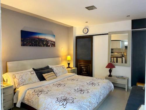 1 dormitorio con 1 cama y reloj en la pared en Apartaestudio El Lugar Ideal Cra. 62 #74-143., en Barranquilla