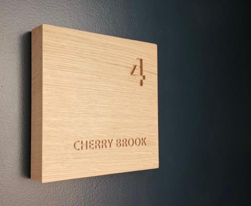 a wooden clock on a wall with the words cherry brook at Furzeleigh Mill Inn in Buckfastleigh