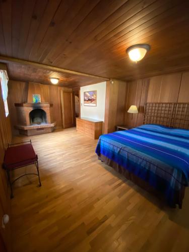 San Lucas SacatepéquezにあるCabaña La Mesetaのベッドルーム(青いベッド1台、暖炉付)