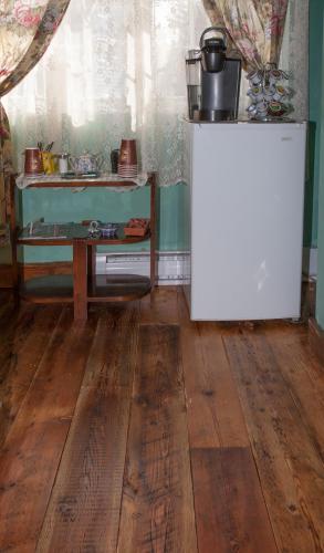 a kitchen with a table and a refrigerator in a room at À Amour et Amitié in Magog-Orford
