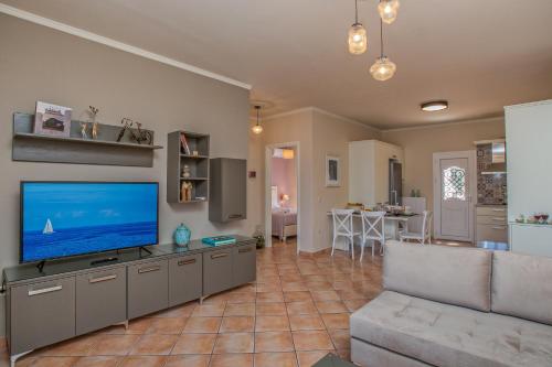 a living room with a flat screen tv and a couch at Dina Apartments Argostoli in Argostoli