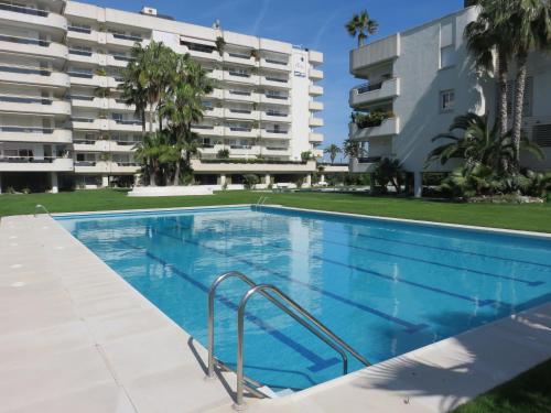 einem Pool vor einem Apartmentgebäude in der Unterkunft Mediterraneo Seaview Apartment by Hello Homes Sitges in Sitges