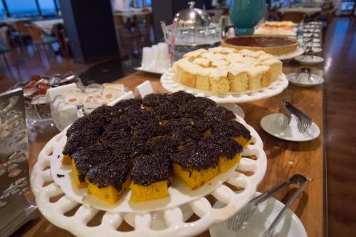 a table with two cakes with cookies on top at Golden Ingá Hotel in Maringá