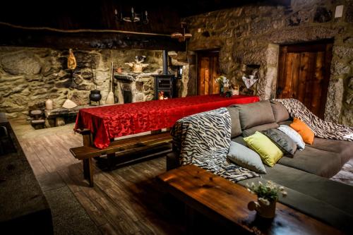 un soggiorno con divano e parete in pietra di Casa das Afonsas a Barral
